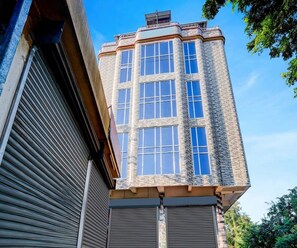 A corner building with a brick facade and multiple windows. - Deluxe Brahmaputra View (Chandanpur)