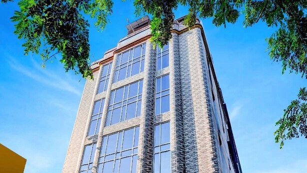 Un immeuble de grande hauteur, doté de nombreuses fenêtres et d’une façade en briques.