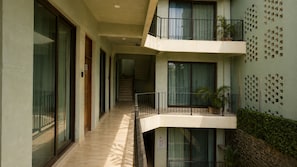 A multi-level residential building with balconies, a staircase, and a wall with square cutouts. - CASA AMOR ZIKATELA (Santa Maria Colotepec)