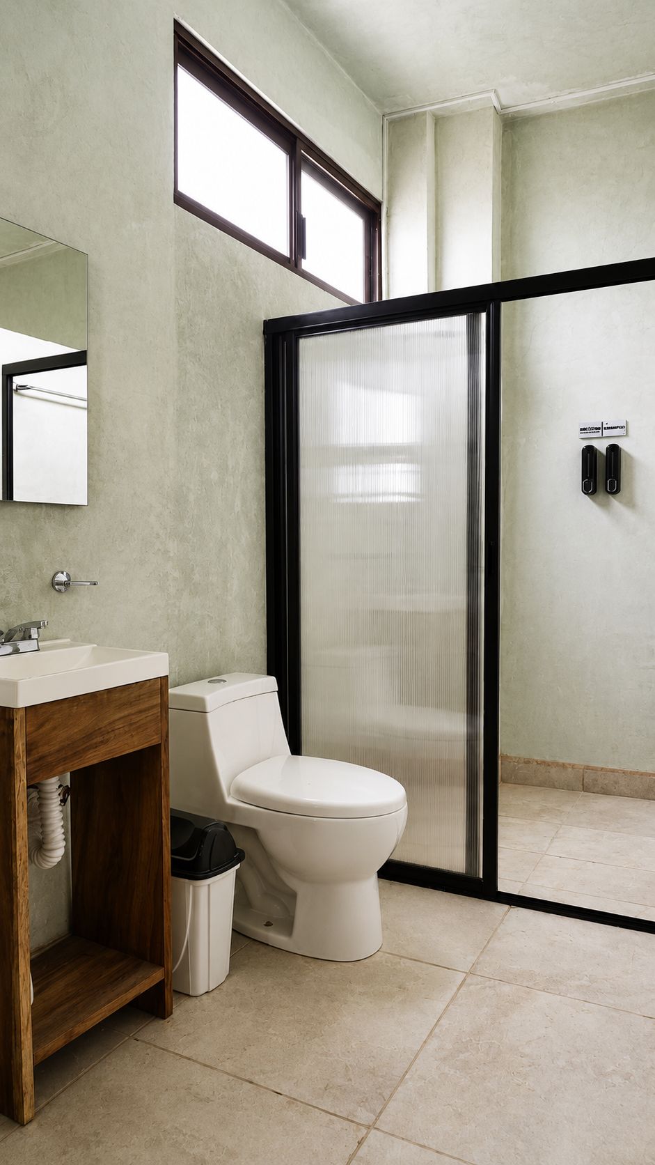 Un baño con inodoro, lavamanos y cabina de ducha.