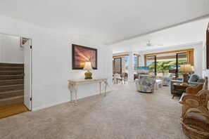 A spacious living area with a carpeted floor, a dining table, and a sofa set. - Kapalua 14T3 | Spacious 3BR Maui Vacation Home (Lahaina)