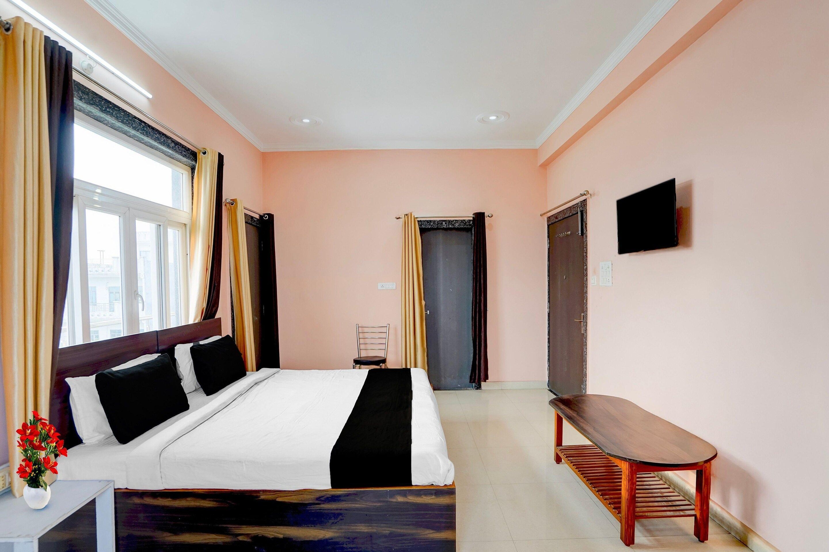 A hotel room with a bed, a chair, a table, and a television.