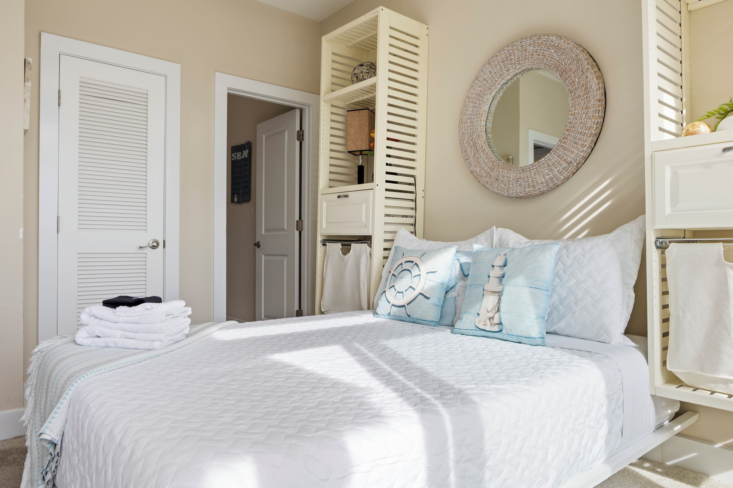 A bedroom with a bed, a round mirror, and a wardrobe.