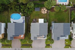 Ein Wohngebiet mit drei Häusern, jedes mit flachem Dach, einer kleinen Terrasse und einer runden Terrasse.