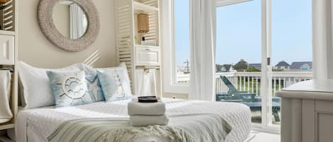 Une chambre à coucher avec un lit, un miroir rond, une armoire et une vue sur l’extérieur.