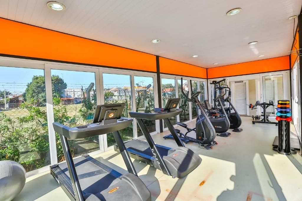 Academia com esteiras, elípticos e equipamentos de musculação.