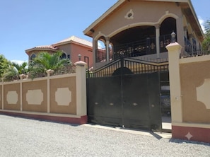 A gated residential property with a covered porch and a driveway.