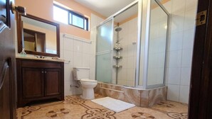Une salle de bain équipée d’une douche, de toilettes, d’un lavabo et de carreaux de sol à motifs.