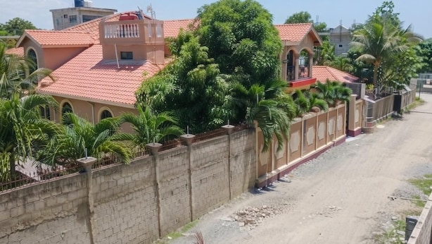 Un quartier résidentiel avec des maisons, une route asphaltée et un mur en briques.