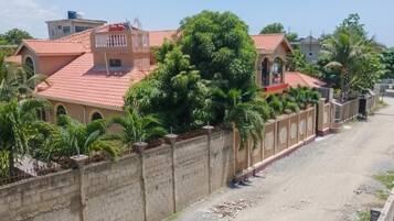 Un quartier résidentiel avec des maisons, une route asphaltée et un mur en briques.