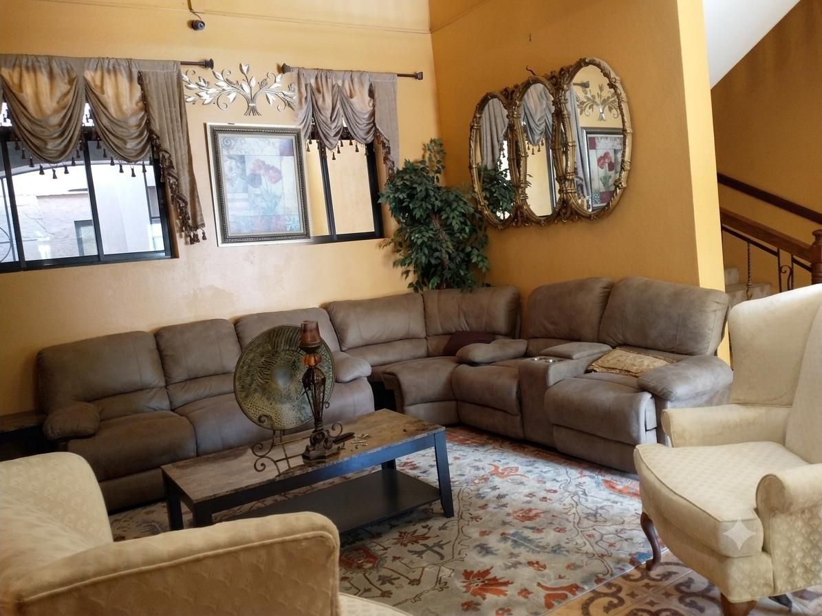 Un salon avec un canapé d’angle, une table basse et un tapis à motifs.