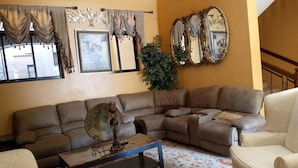 Un salon avec un canapé d’angle, une table basse et un tapis à motifs.