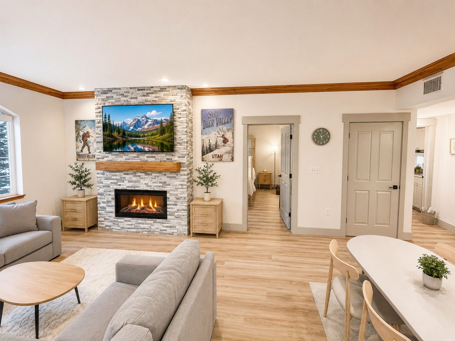A modern living room with a fireplace, a sofa, a dining table, and a hallway leading to a bedroom.
