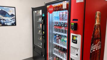 A vending machine with a Coca-Cola logo, a selection of beverages, and a Coca-Cola bottle.
