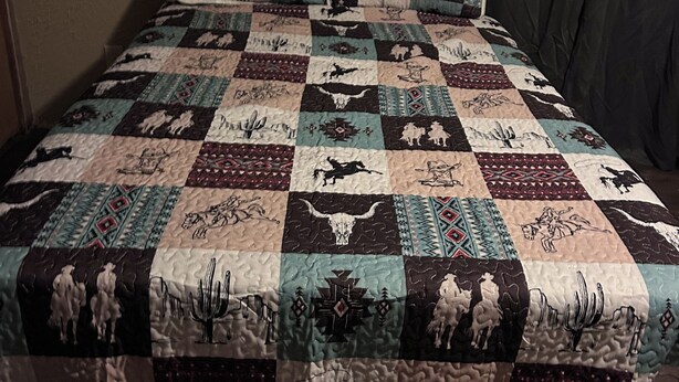Ein Bett mit einer Tagesdecke, die verschiedene Tiermuster und -drucke zeigt.
