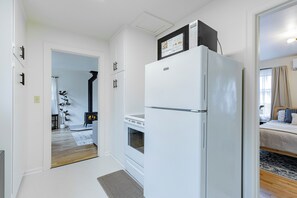 A compact kitchen with a white refrigerator, a stove, and a small oven.