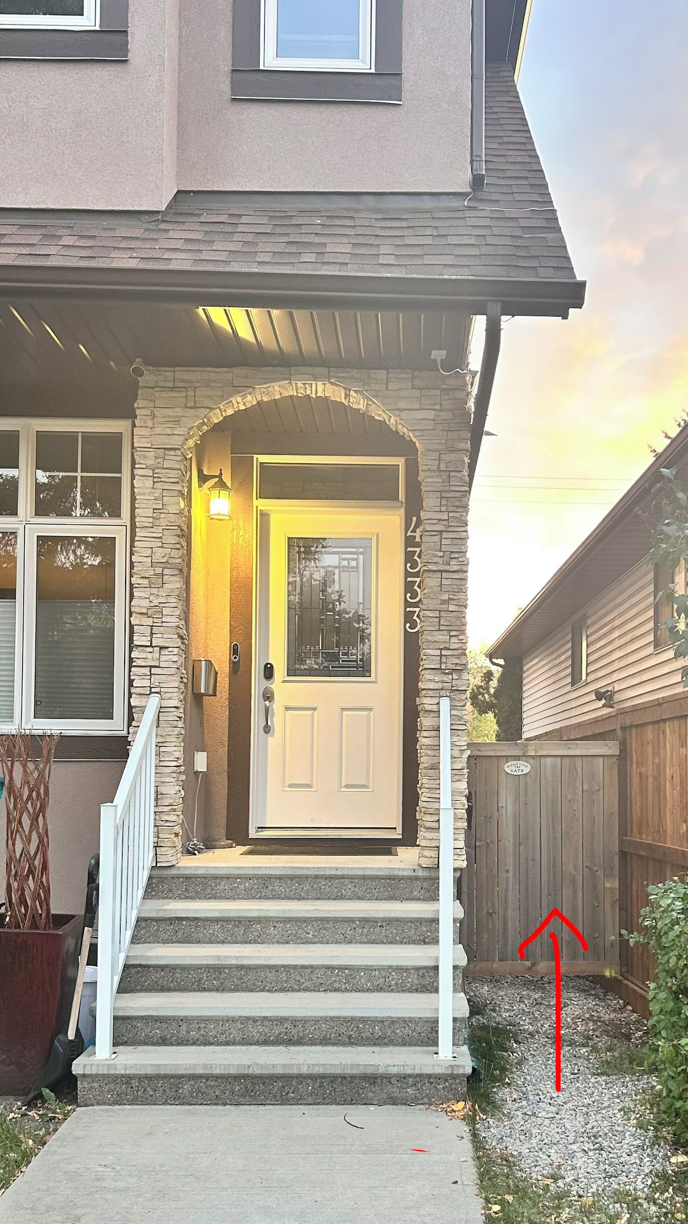 Une maison d’habitation avec une façade en pierre, une porte d’entrée et un escalier menant à l’entrée.