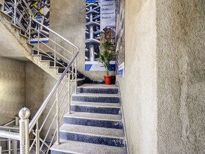 A staircase with metal railings and a potted plant. - Deluxe Hotel Sapphire Grand (Ranchi)