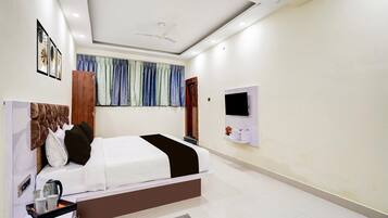 Un dormitorio moderno con una cama grande, un televisor de pantalla plana montado en la pared y un ventilador de techo.