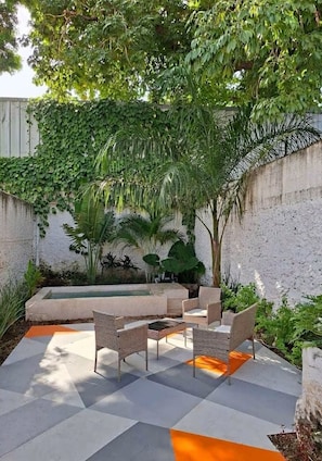 A patio with outdoor furniture, a pool, and lush greenery. - Authentic Downtown Charm with Plunge Pool & Fast Wi-Fi | Long-Stay Discount (Mérida)