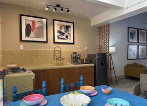 A kitchen with a dining table set for four, a refrigerator, and a coffee machine. - Authentic Downtown Charm with Plunge Pool & Fast Wi-Fi | Long-Stay Discount (Mérida)