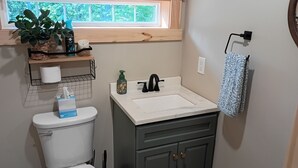 Une salle de bain avec des toilettes, un lavabo et une fenêtre.