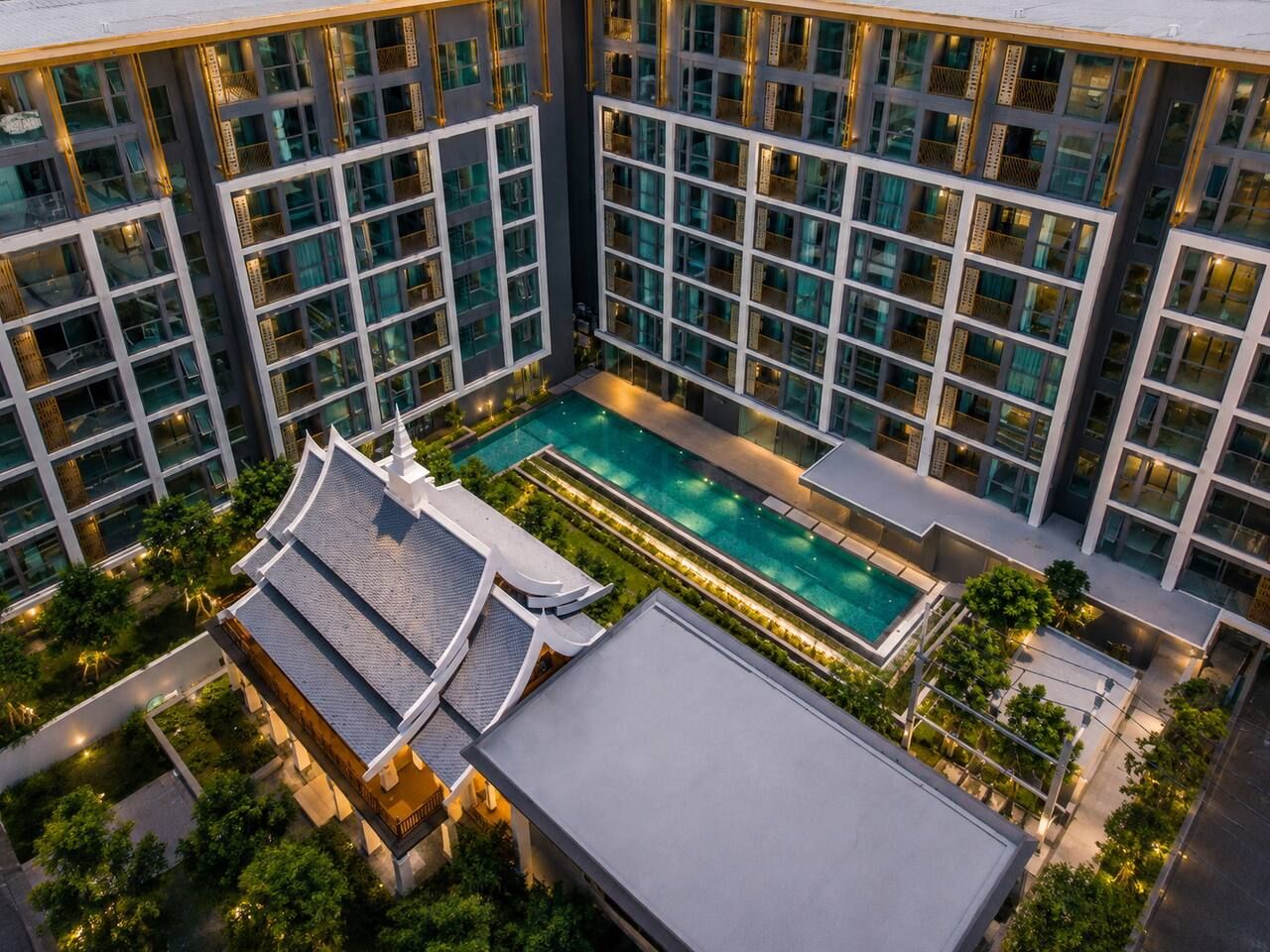 A modern hotel with a rooftop pool and traditional architectural elements.