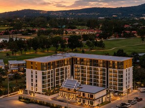 A multi-story hotel with a modern design, featuring a central courtyard and multiple balconies. - 1BR Felix Suite Bangtao Beach (Tambon Choeng Thale)