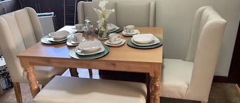 A dining table set with plates, cups, and a vase of flowers.