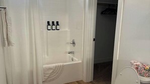 Un bagno con vasca, WC e tenda da doccia.