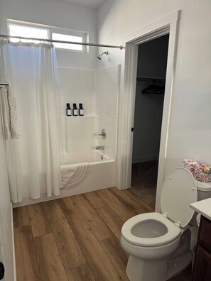 Un baño con bañera, inodoro y cortina de ducha.