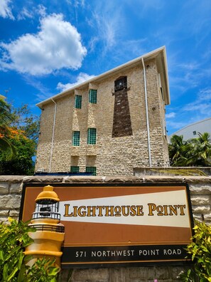 A building with a sign reading 'Lighthouse Point' and '571 Northwest Point Road'. - Amazing Oceanfront Condo w Onsite Diving and Restaurant (West Bay)