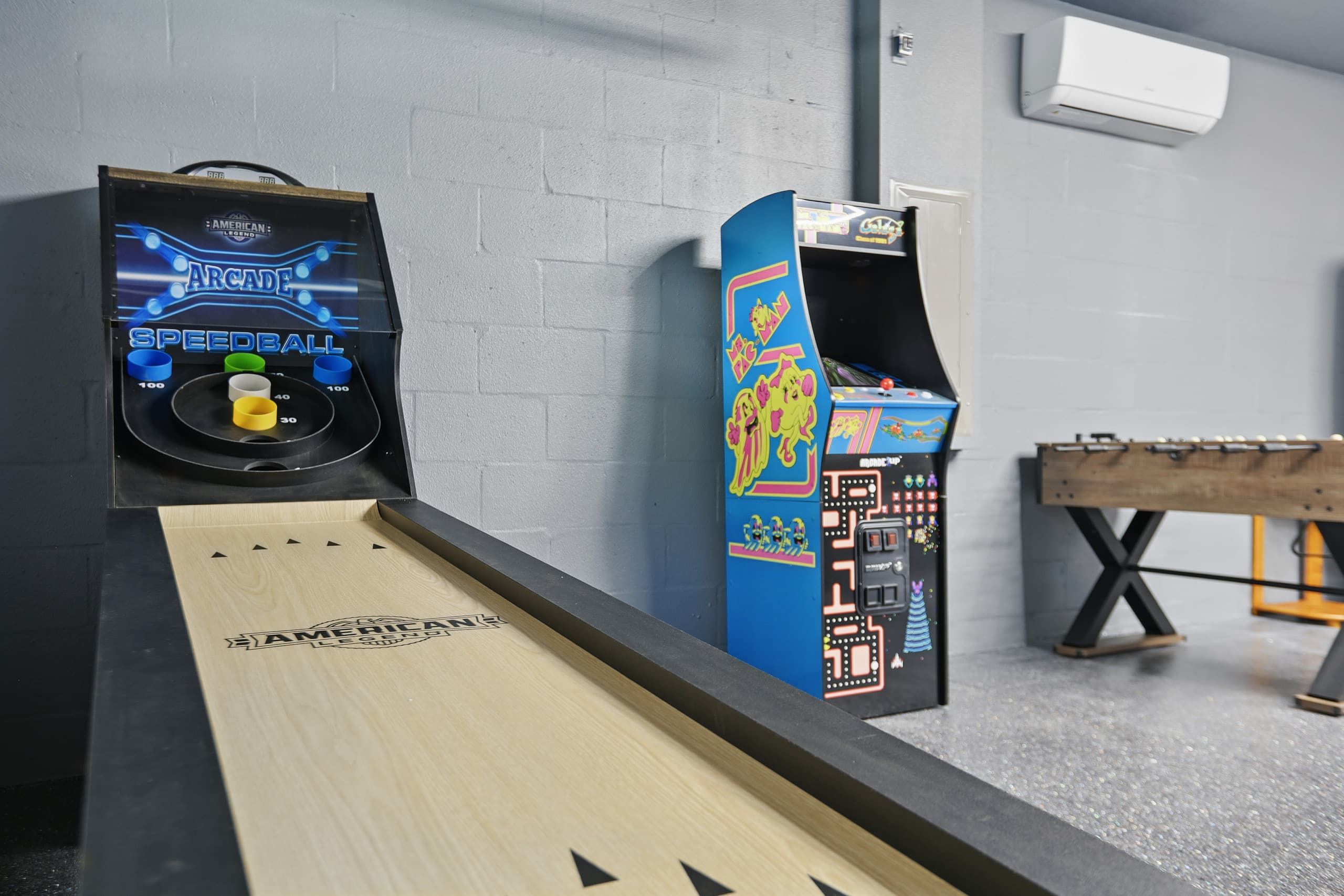 A bowling alley with two bowling machines and a wooden bowling lane.