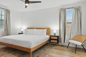 A bedroom with a bed, nightstands, a chair, a ceiling fan, and a window with curtains. - Disney Vacation Pool Home | Resort | Game Room (Davenport)
