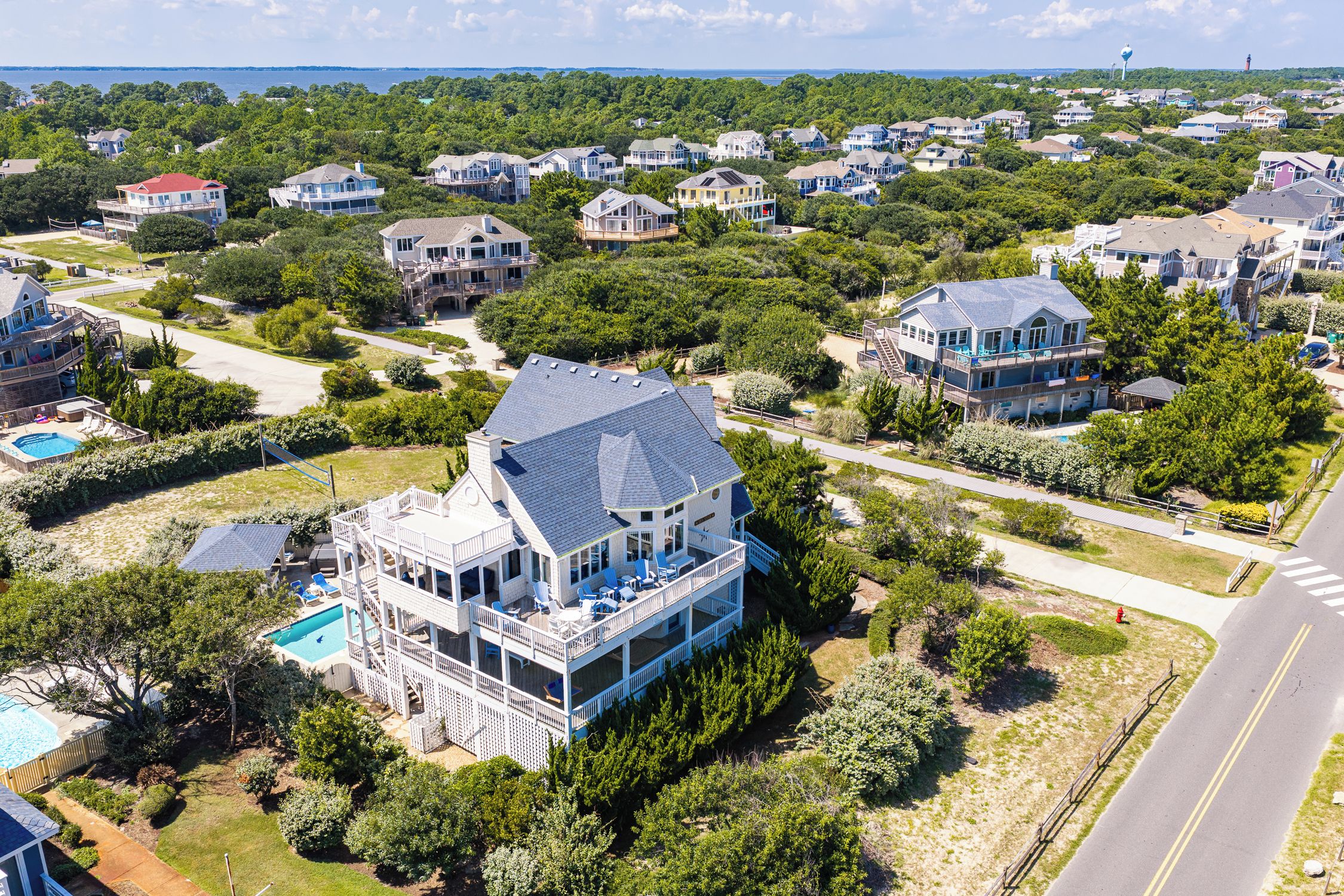 A large house with multiple decks and a swimming pool.