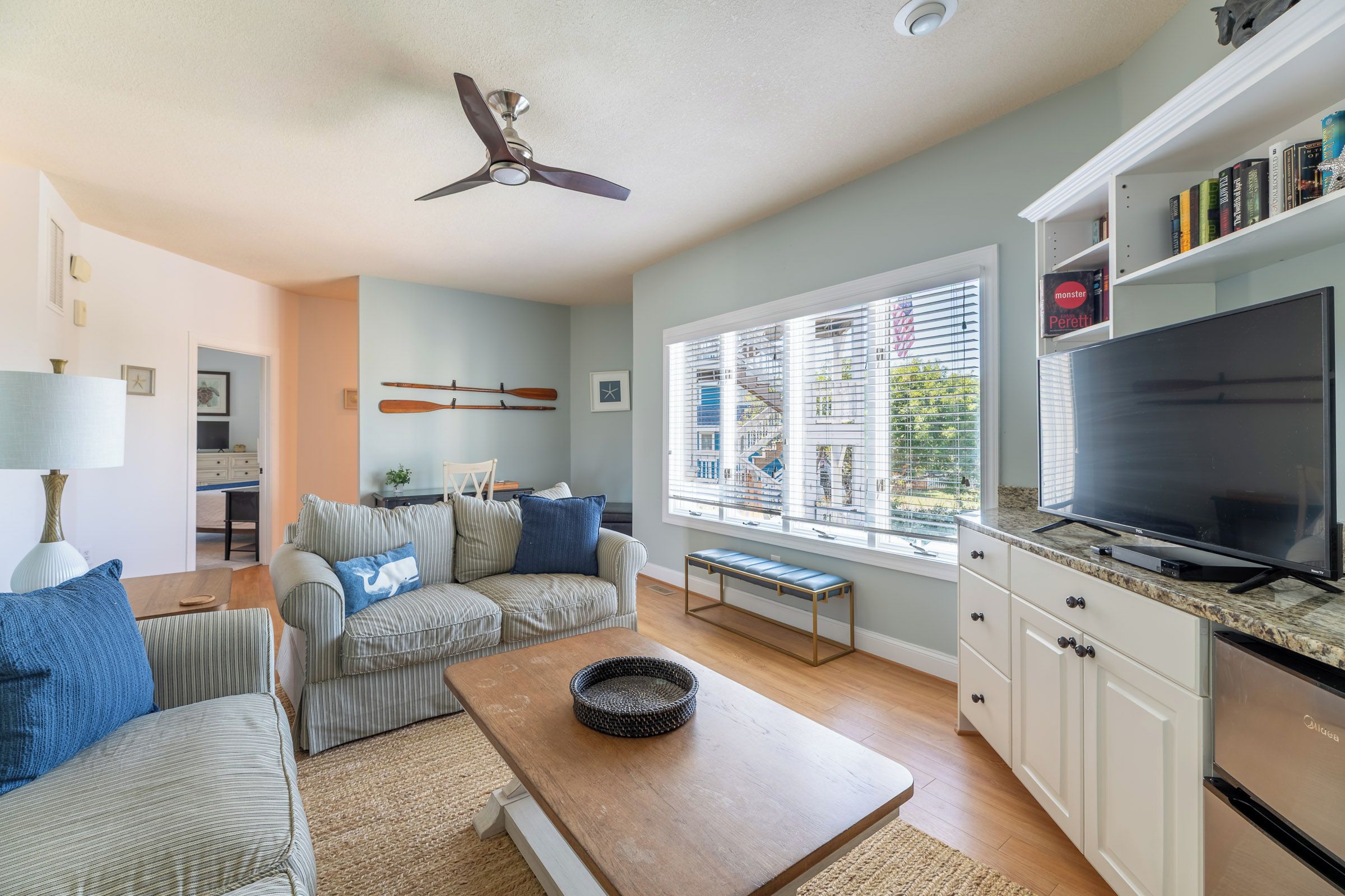 A modern living room with a sofa set, a coffee table, a TV, and a bookshelf.