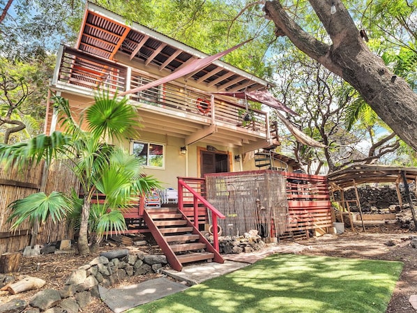 A two-story house with a red staircase, a balcony, and a garden with palm trees. - Authentic Eco-estate in Kona sleeps 14 -Living in Harmony with nature by the sea (Kailua-Kona)