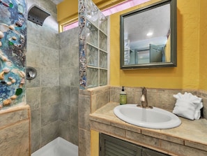 A bathroom with a shower, a sink, and a mirror. - Authentic 5-bedroom estate in Kailua-Kona Living in Harmony with nature (Kailua-Kona)