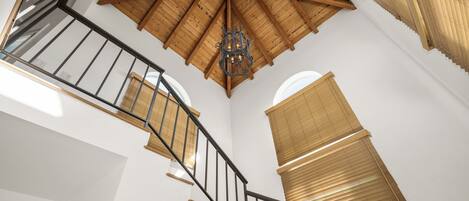 Un escalier en colimaçon avec des rampes et un plafond en bois.