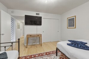 A bedroom with a bed, a desk, a chair, a television, and a wardrobe. - Gated Austin 2BR Condo+ Pool - Near South Congress (Austin)