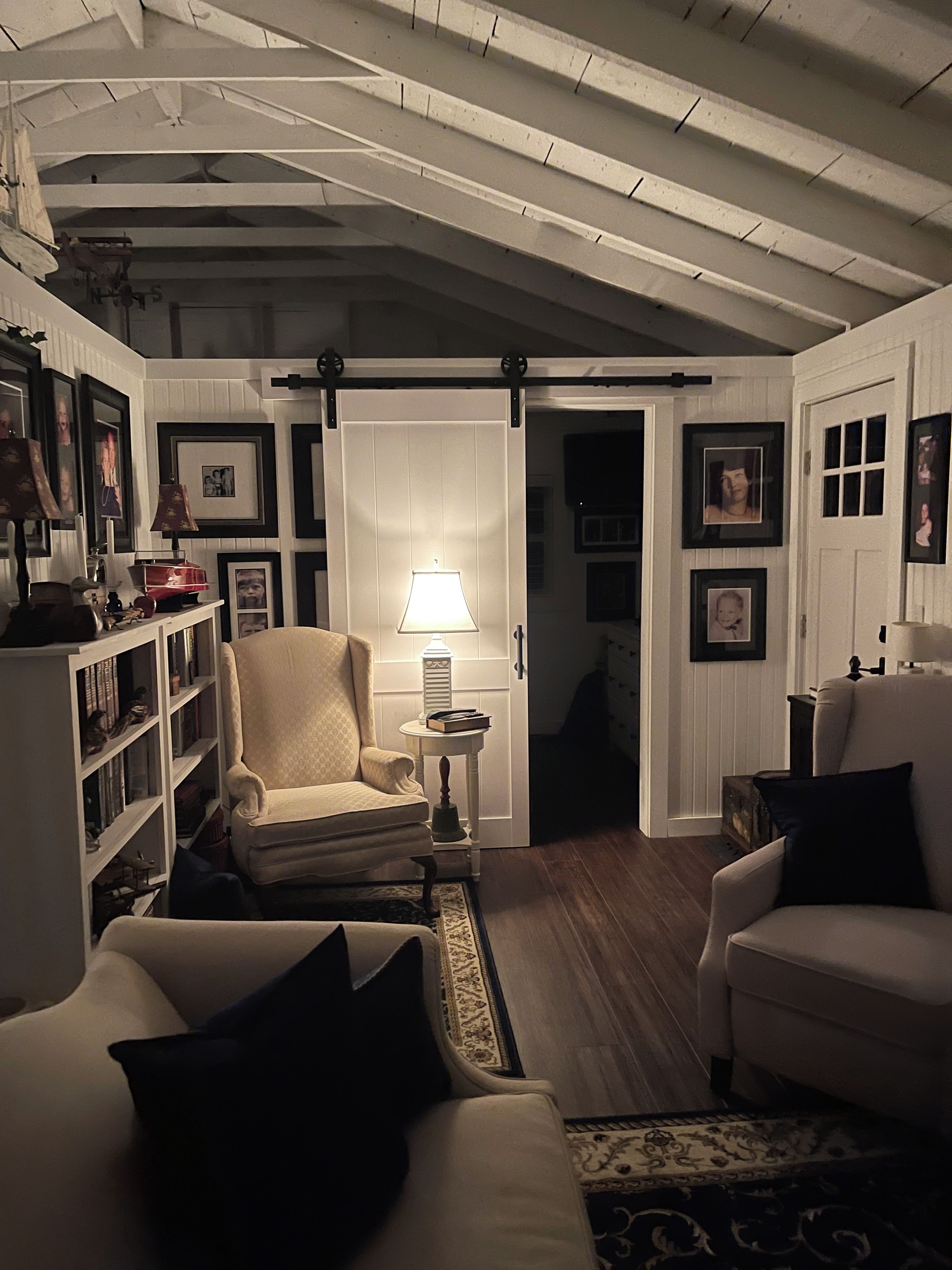 Un salon confortable avec un canapé, un fauteuil et une bibliothèque.