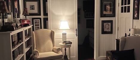 Una sala de estar acogedora con un sofá, un sillón y una estantería.
