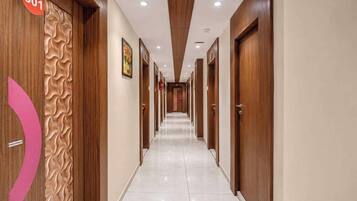 Un couloir d’hôtel avec des portes en bois, numérotées 301, et un sol carrelé.
