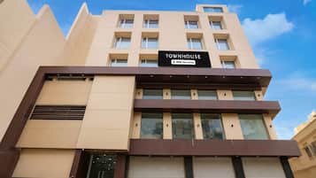 A multi-story building with a sign reading 'TOWNHOUSE' and 'OYO-Serviced'.
