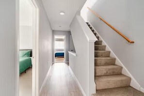 Ein Flur mit einer Treppe, die zu einem Schlafzimmer führt.