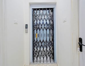 A white door with a black metal security gate. - Classic MJR Square Mall (Hyderabad)