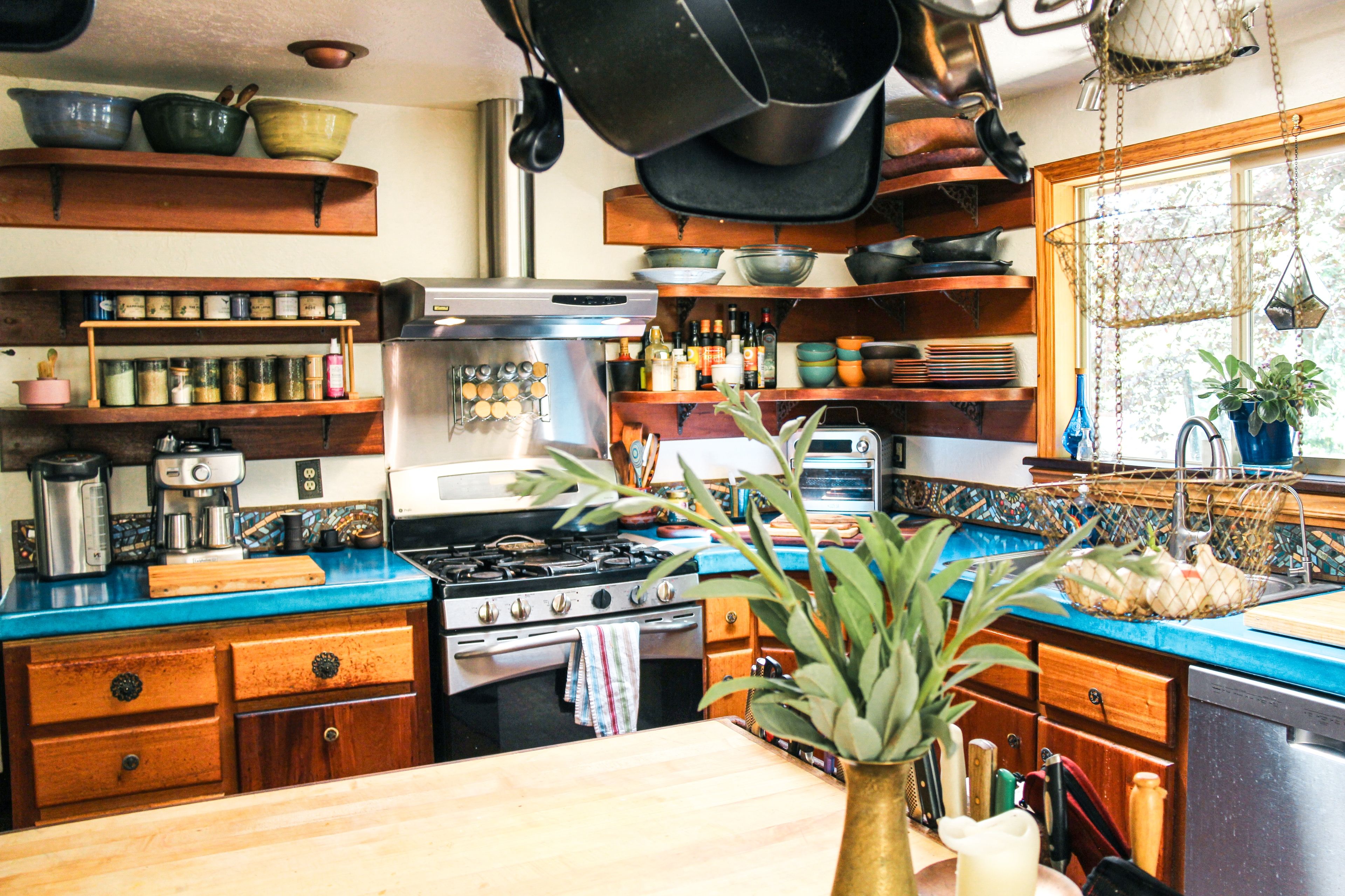 Een keuken met houten kastjes, een roestvrijstalen fornuis en diverse keukengerei.