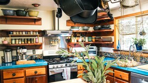 Una cucina con mobili in legno, un piano cottura in acciaio inossidabile e diversi utensili da cucina.