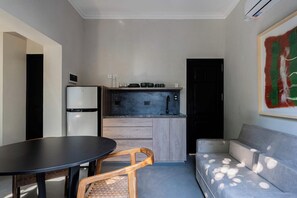 A compact living space with a kitchenette, a dining table, and a sofa. - MOT Rentals River Plate 2 Lux Lofts B - 100m to Stadium (Buenos Aires)