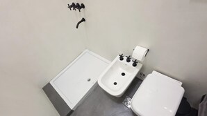A bathroom with a bathtub, a bidet, and a toilet. - MOT Rentals River Plate Loft 1 - 100m to Stadium (Buenos Aires)